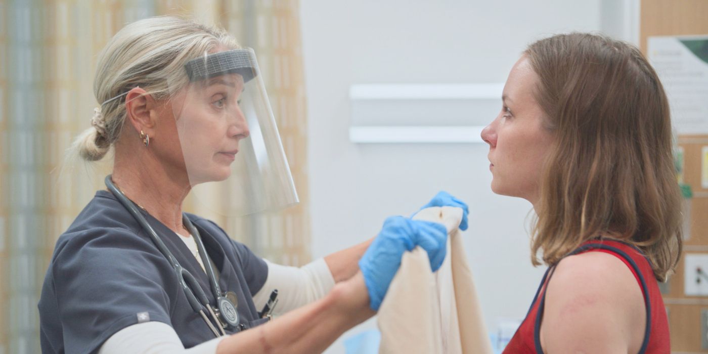 Dana wearing a face shield and holding a privacy sheet in front of Ilana Miller in The Pitt Season 2 Episode 7