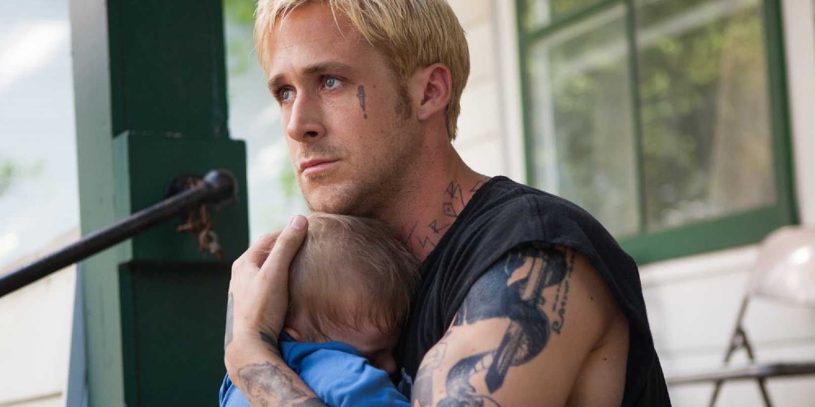 Ryan Gosling holds a baby tightly in The Place Beyond the Pines