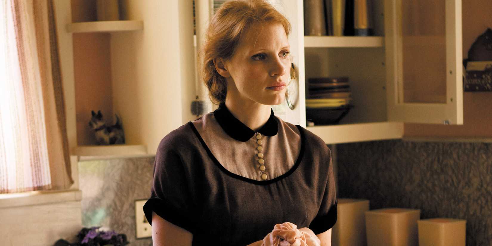 Jessica Chastain standing in a kitchen looking serious in The Tree of Life
