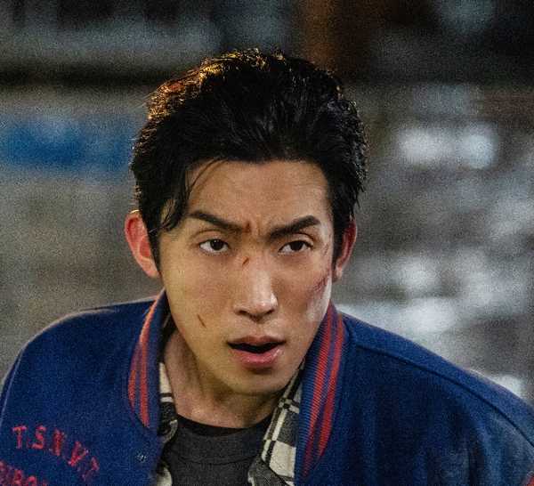 Lee Sang-yi frowning at someone off-screen, with scratches on his face, in Bloodhounds