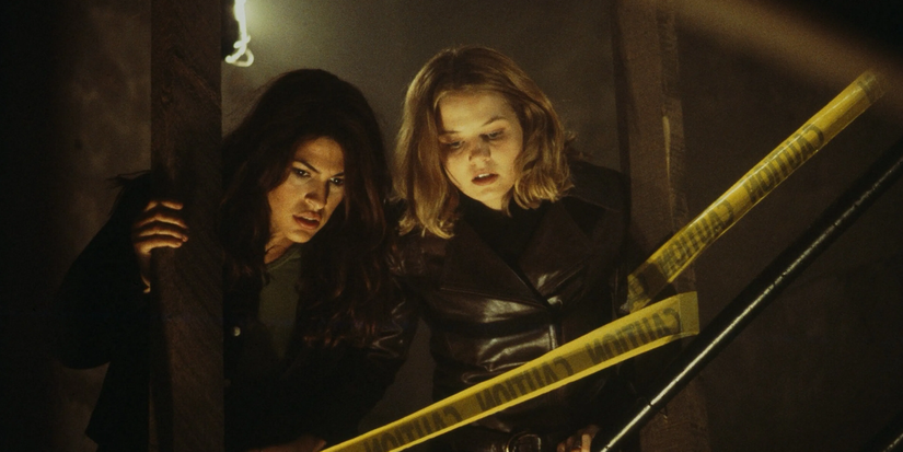 A brunette and a blonde girl looks downwards