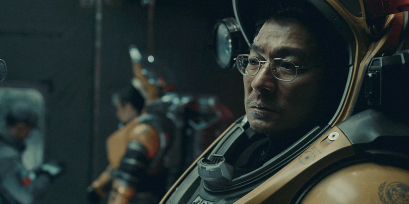 A weary man with glasses wears an exoskeleton suit