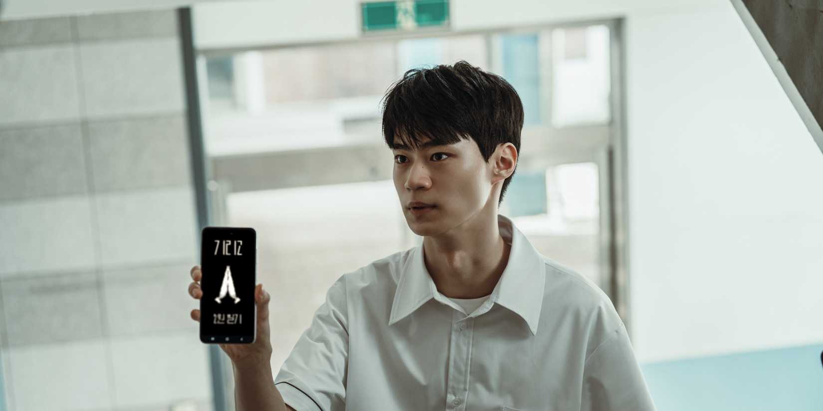 Hyun Woo-seok showing a deadly app to someone off-screen in If Wishes Could Kill