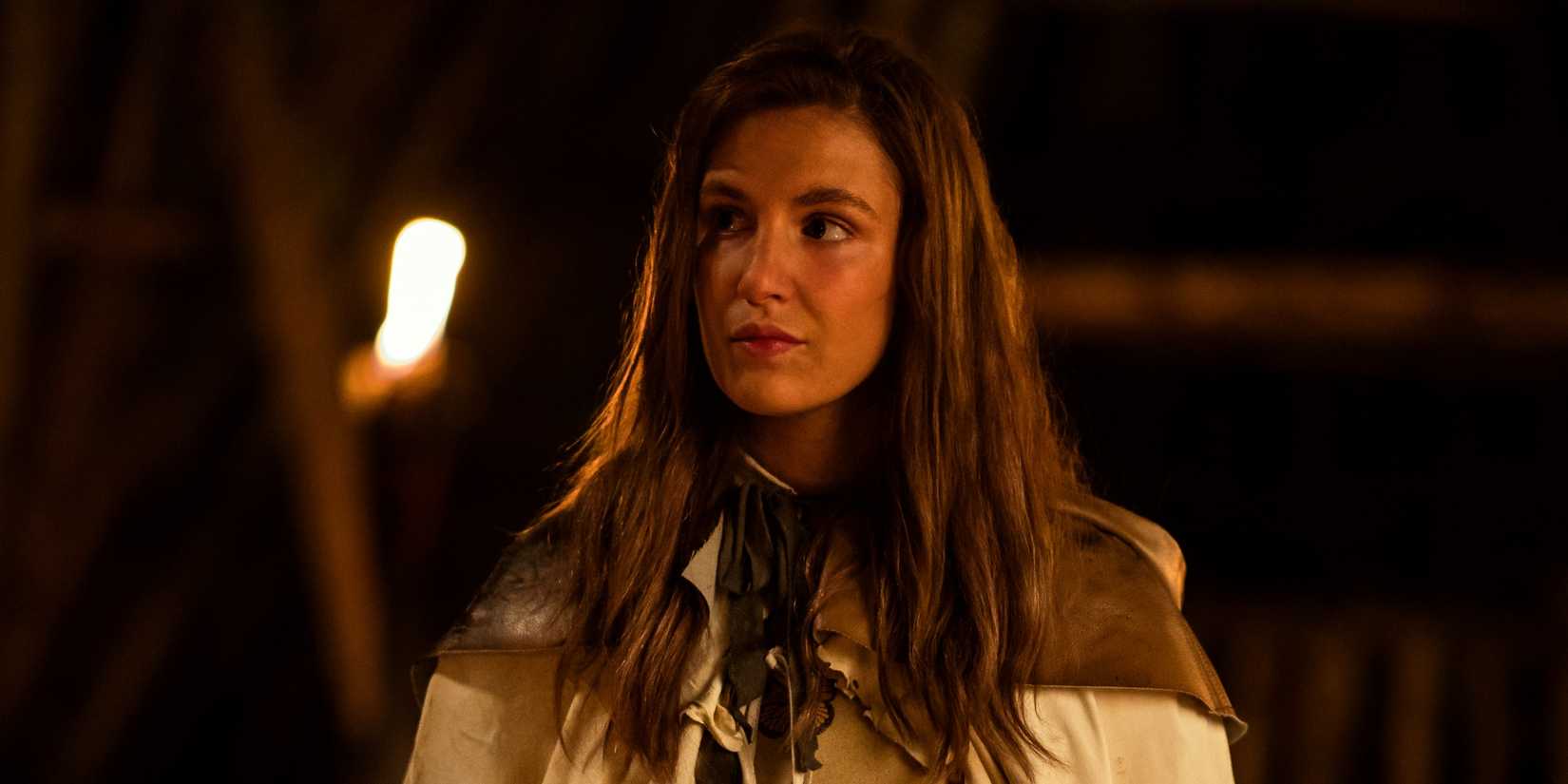 Sophie Nélisse as Teen Shauna standing in the woods at night with a smirk in Yellowjackets Season 3