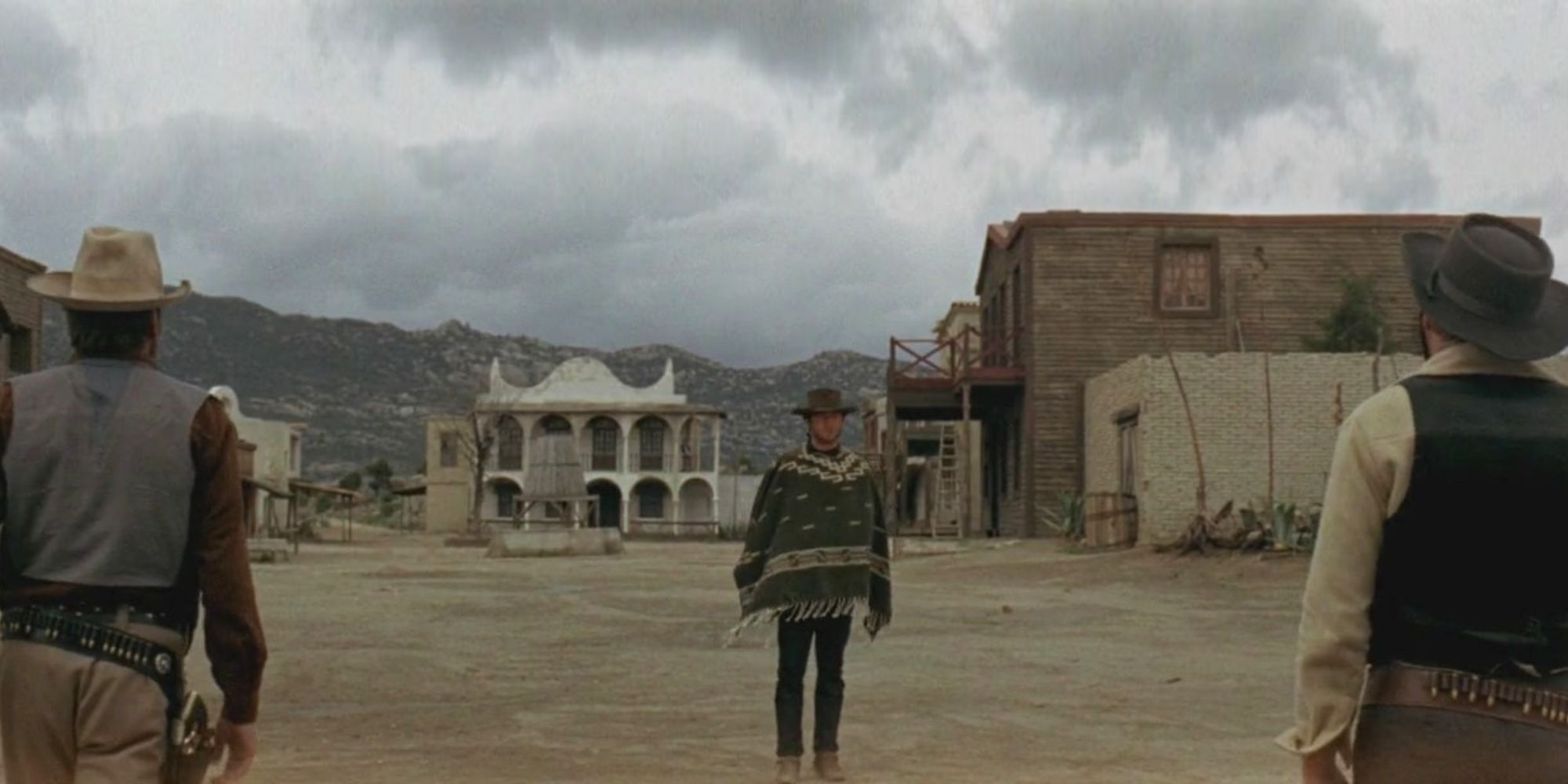 The Man with No Name approaching two other men in A Fistful of Dollars