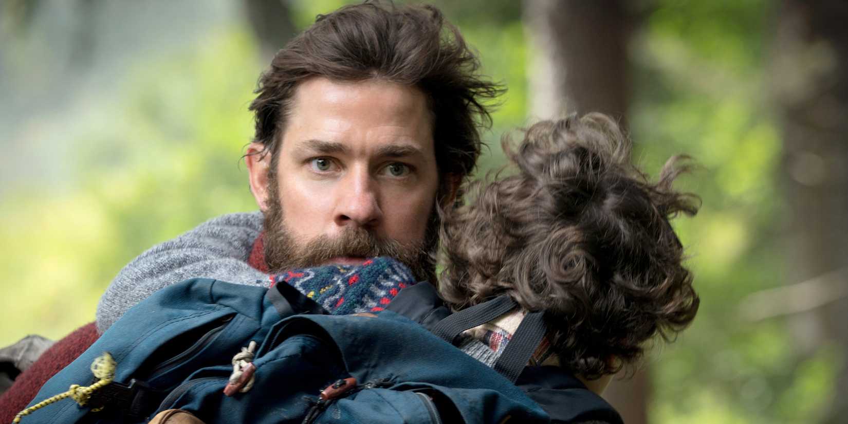 John Krasinski carrying Cade Woodward in A Quiet Place
