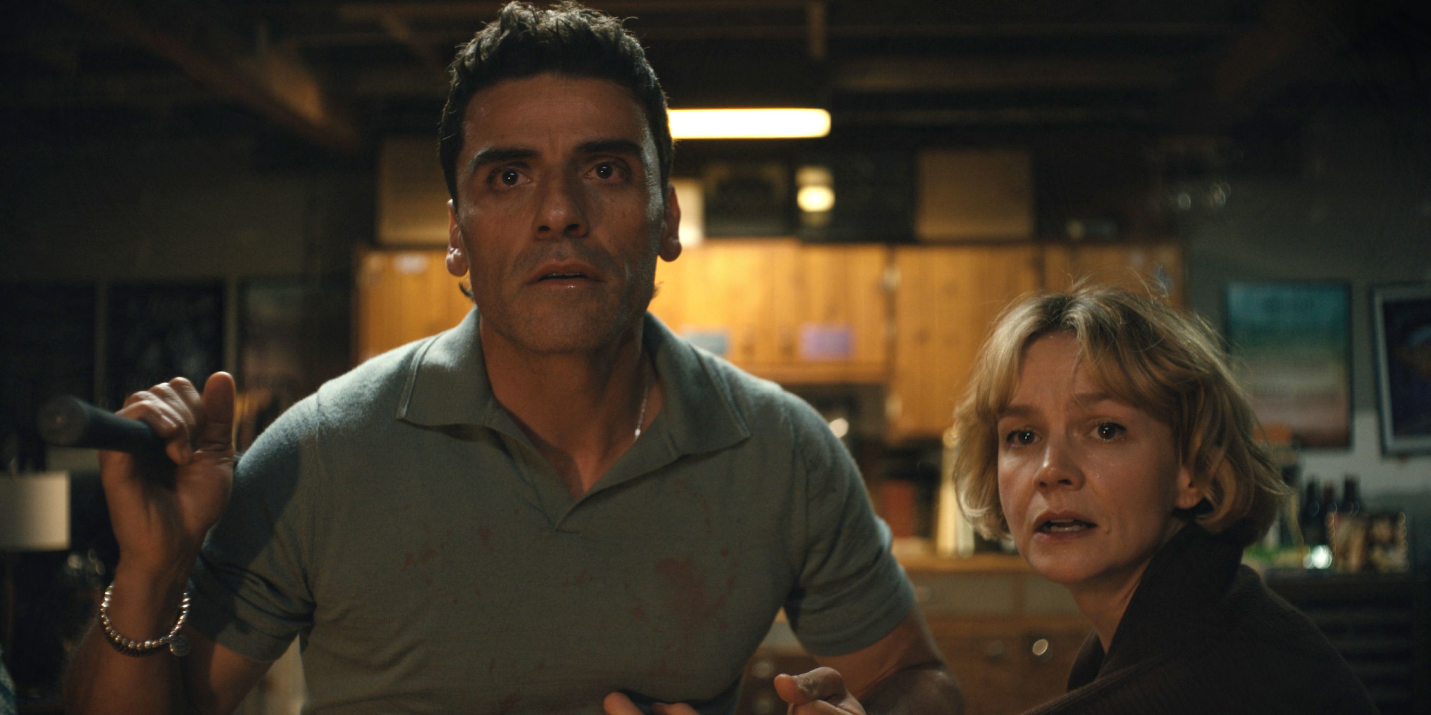 Oscar Isaac and Carey Mulligan staring worriedly at something out their window in Beef Season 2
