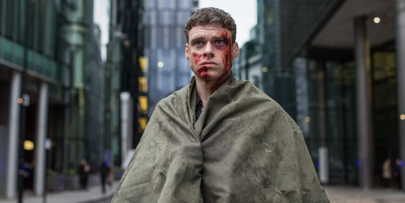 David with a bloody face wrapped in a blanket in the middle of thee street in Bodyguard.