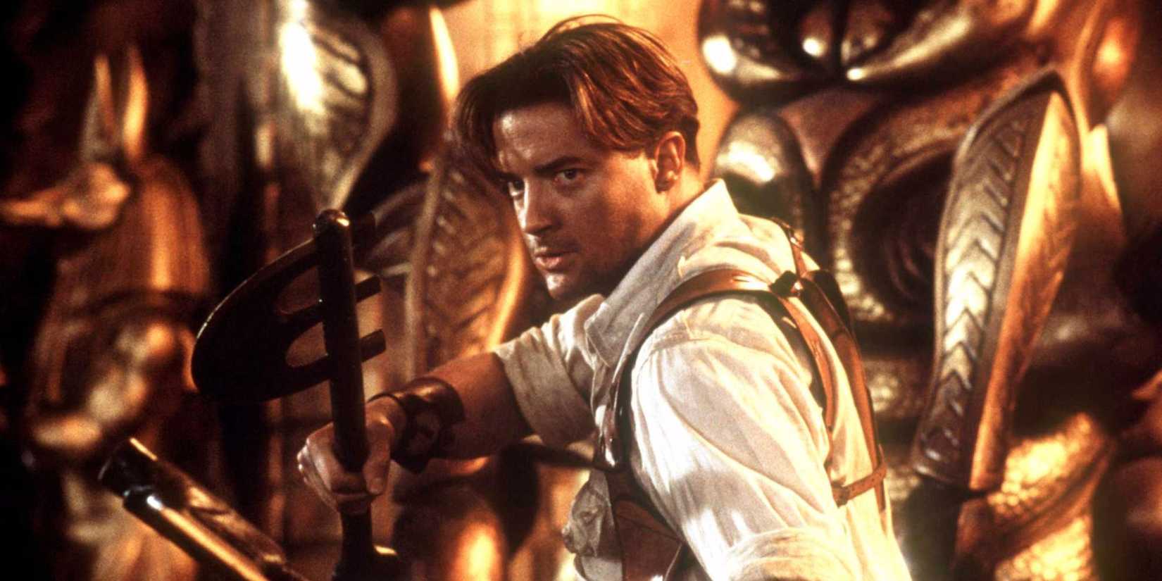 Brendan Fraser holding a weapon at the ready in The Mummy