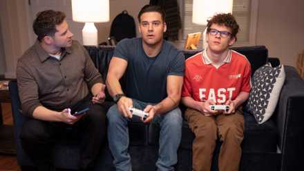 Buck, Eddie, and Christopher sitting on the couch playing video games in 9-1-1 Season 9 Episode 12