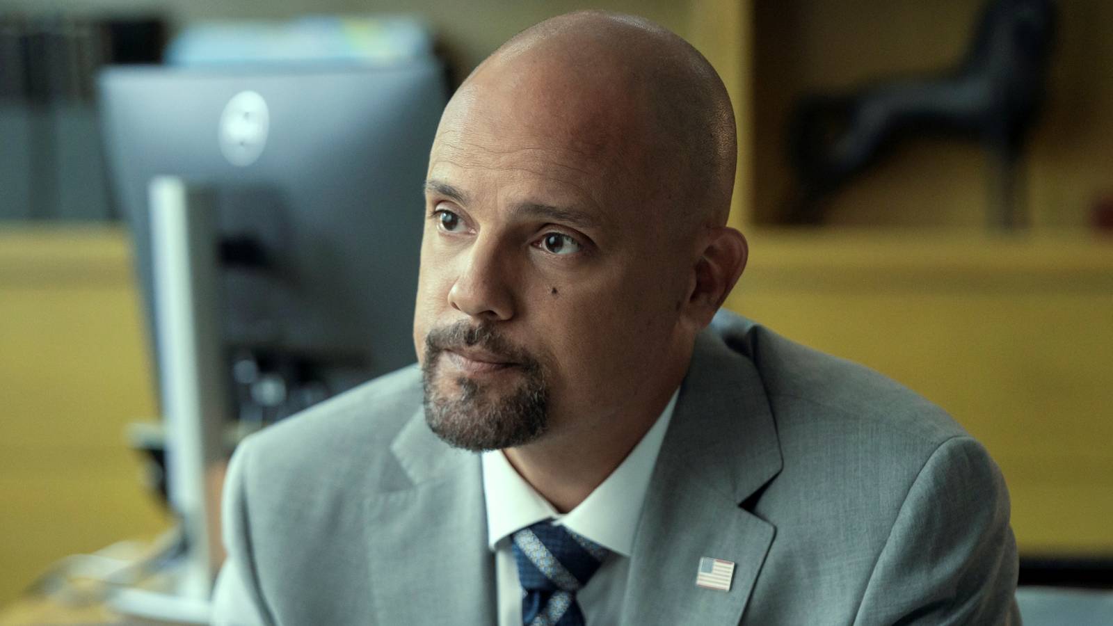 Showrunner Ben Watkins, who also plays Roy, looking serious in a suit in Cross Season 2