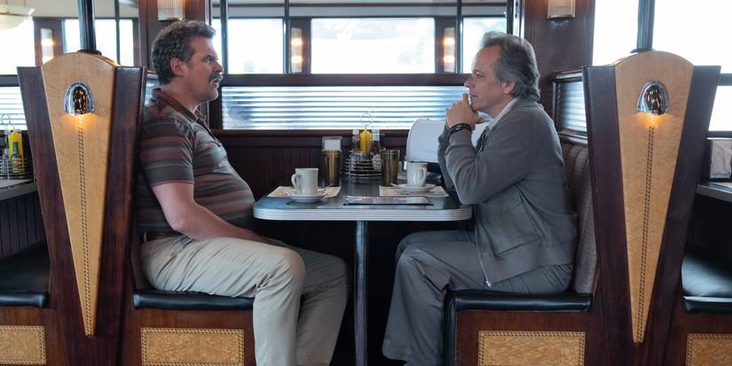 David Harbour as Floyd and Peter Sarsgaard as Modern Love sitting scross from each other in DTF St. Louis