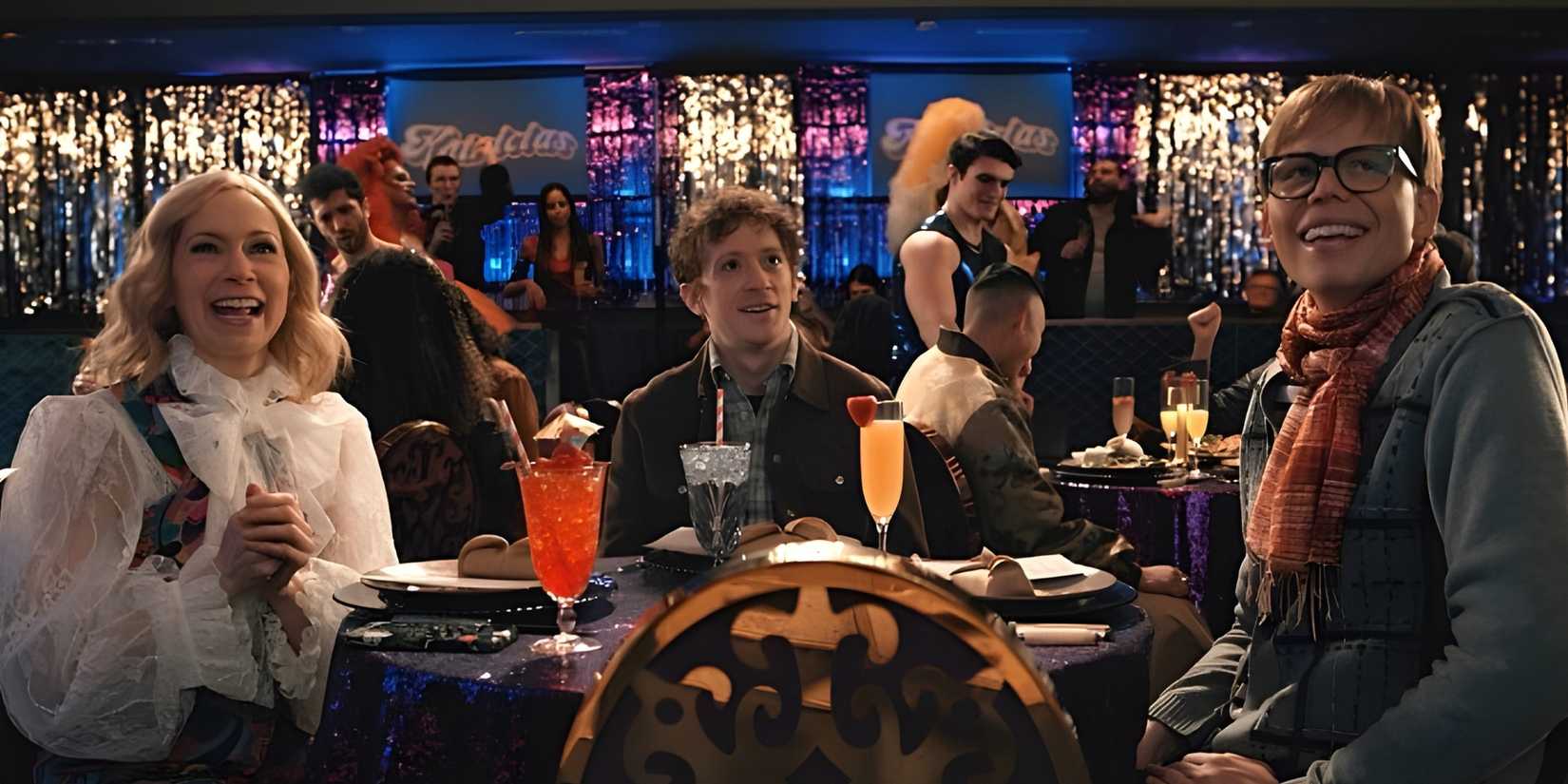 Elsbeth (Carrie Preston), in a blonde wig, with Officer Chandler (Ethan Slater) and Felix West (Jeff Hiller) at a drag show in the Elsbeth episode "All's Hair."