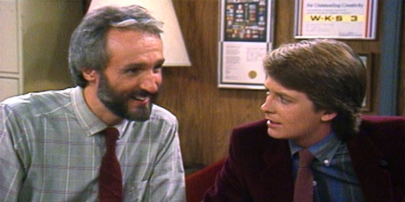 A dad and son smiling and talking in Family Ties.