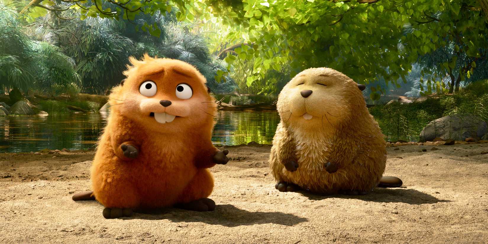 Two beavers stand by the edge of a river.