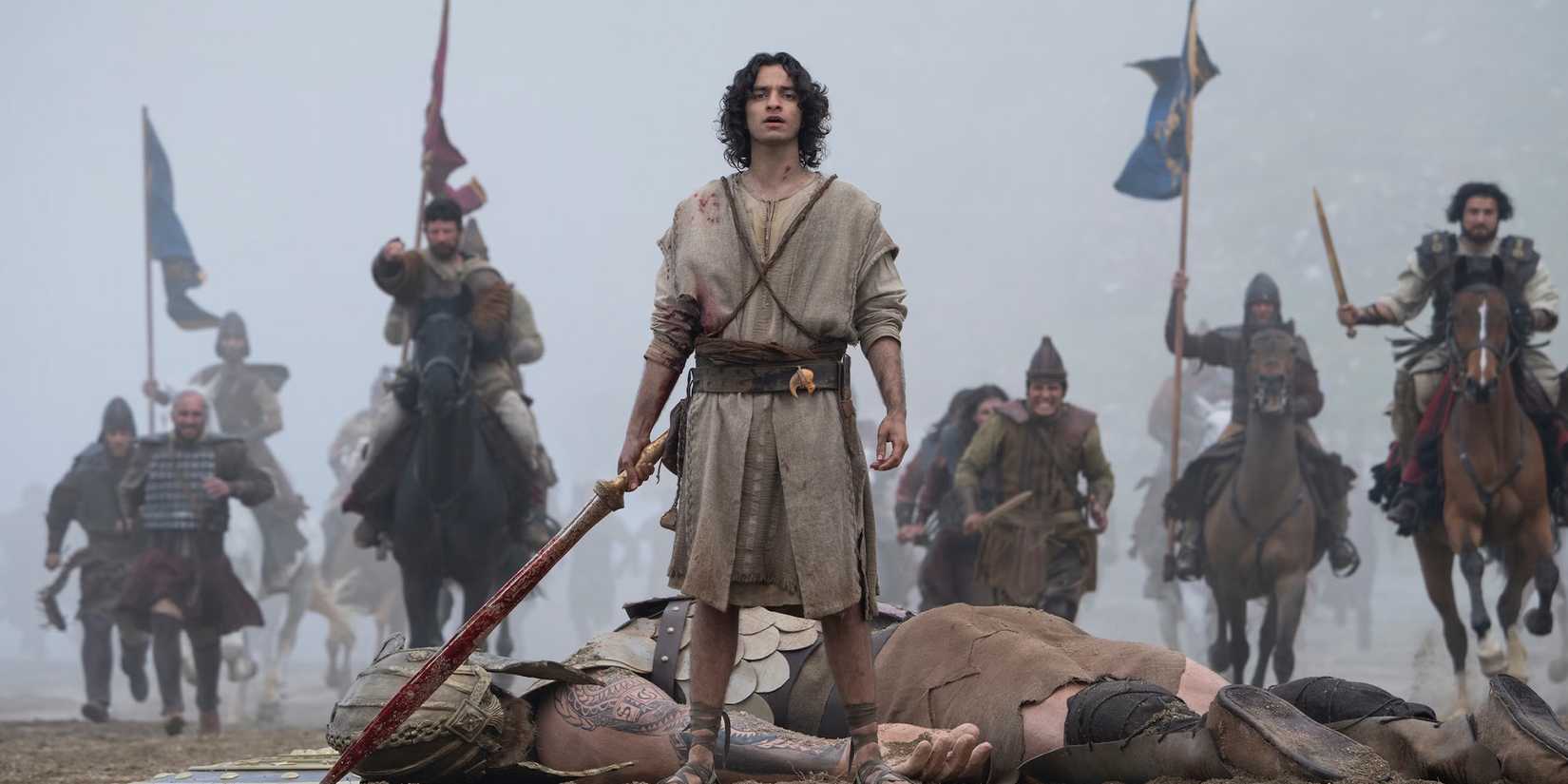 David (Michael Iskander) stands over the body of Goliath as warriors ride up in 'House of David' Season 2