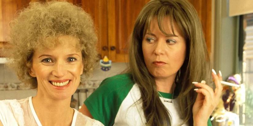 Kath (Jane Turner) smiling at the camera while Kim (Gina Riley) stares at her.