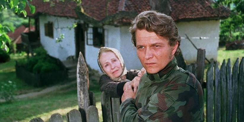 Man with his mother in front of cottage in 'Pretty Village, Pretty Flame'