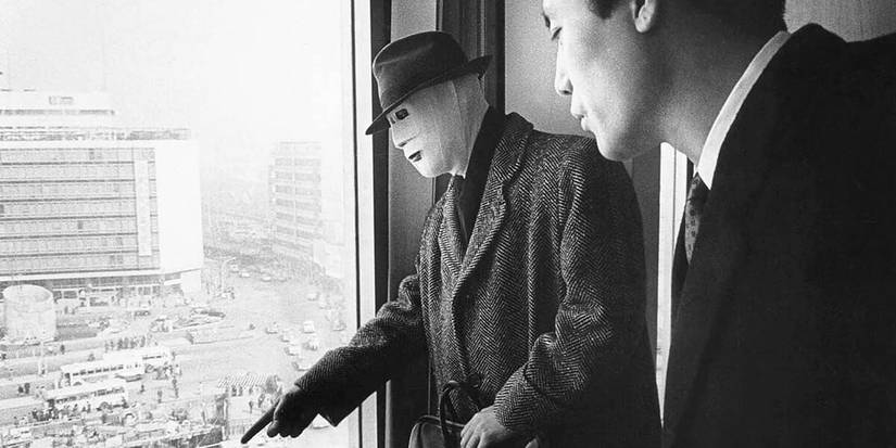 Man with mask pointing out a window in 'The Face of Another'