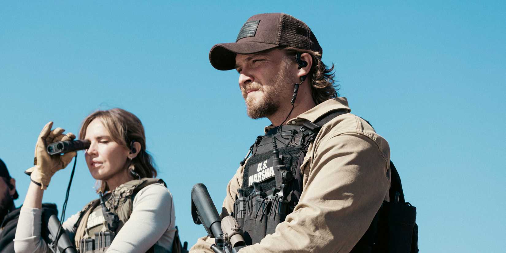 Luke Grimes as Kayce Dutton in his gear watching something from afar in Marshals Season 1