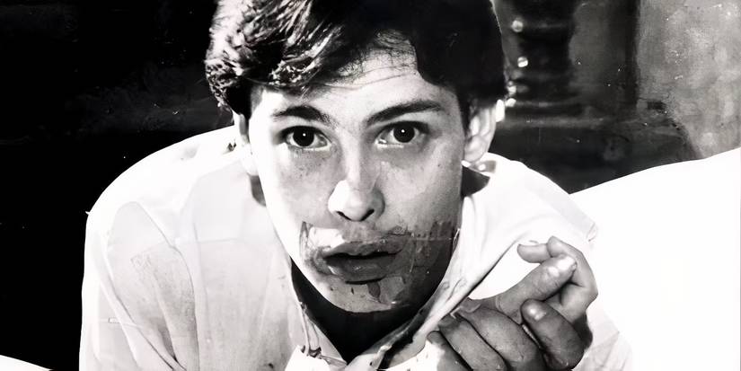 John Amplas holding someone's wrist and looking at the camera with a bloody mouth in George Romero's Martin