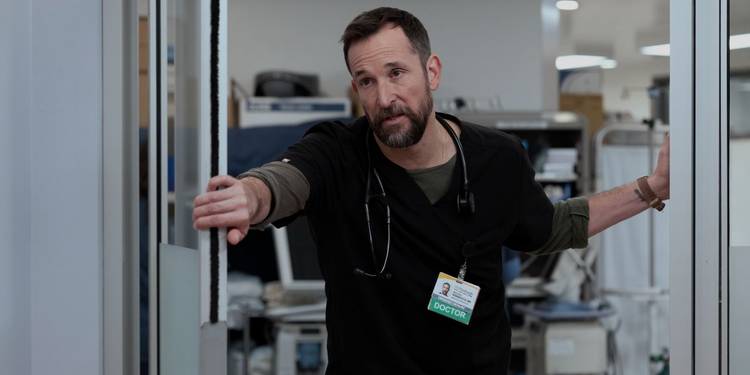Dr. Robby (Noah Wyle) standing inside a door frame on 'The Pitt'