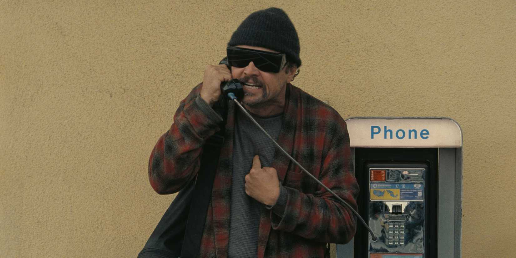 Leonardo DiCaprio pointing at himself while on the phone in One Battle After Another