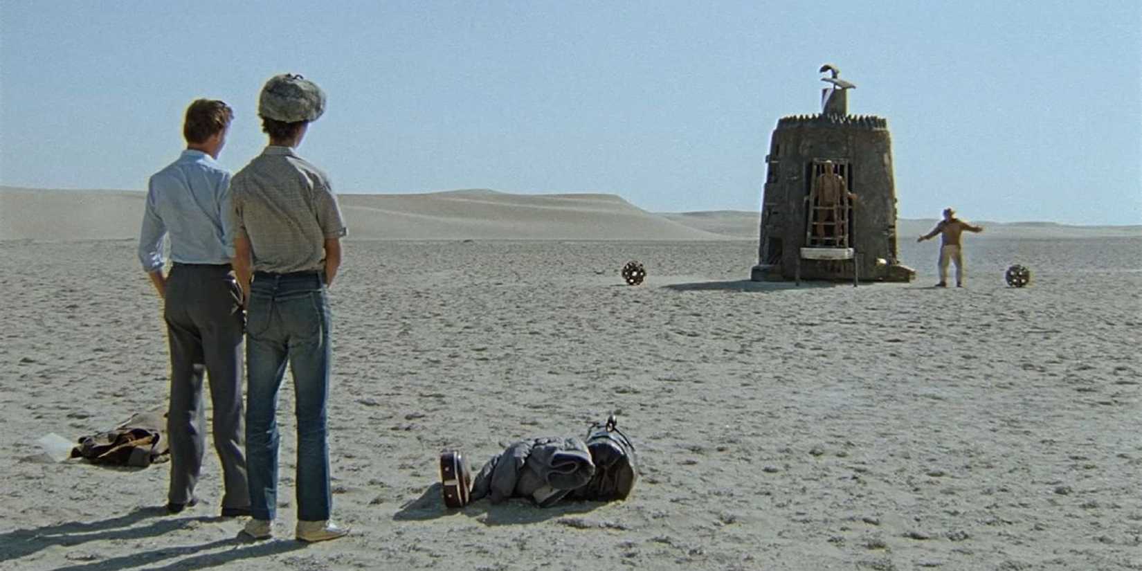 People looking at a cage in the desert in 'Kin-dza-dza'