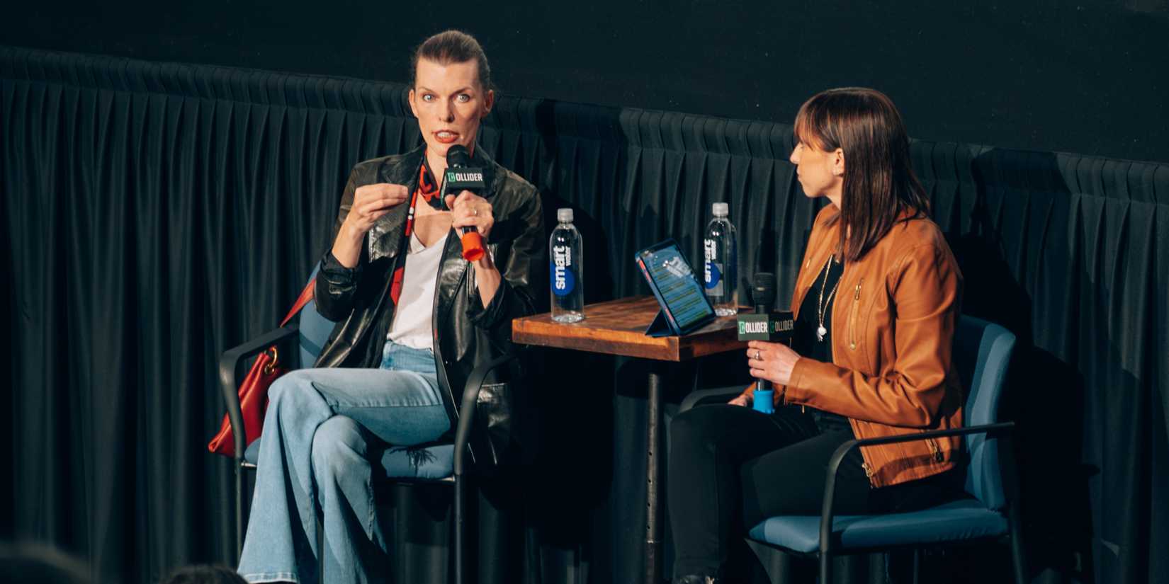 Milla Jovovich speaks on stage for Collider's Protector Q&A.