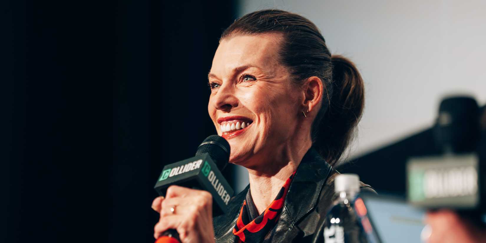 Milla Jovovich speaks on stage for Collider's Protector Q&A.