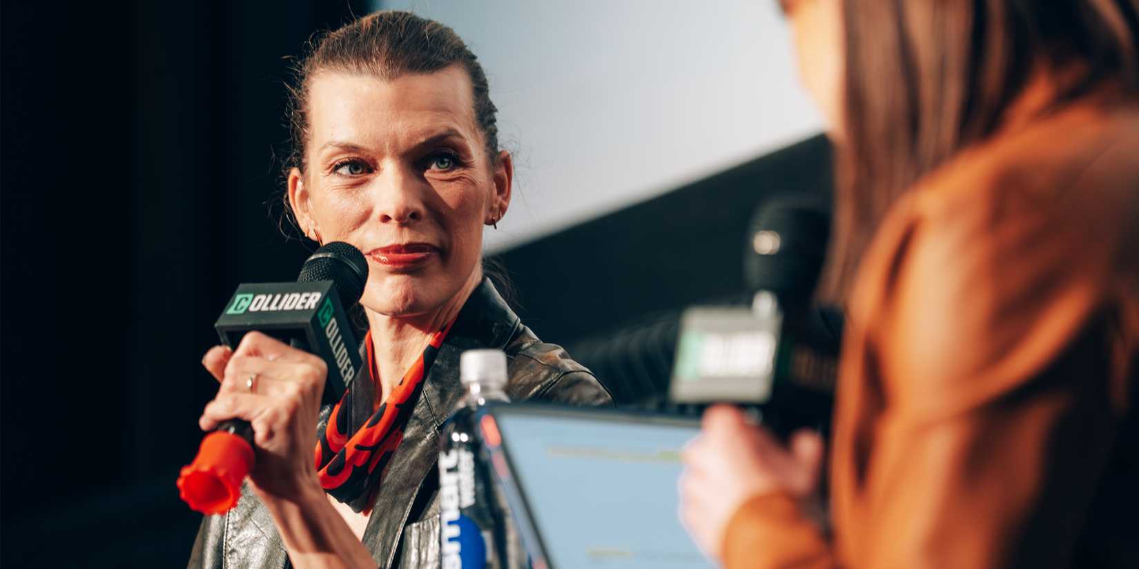 Milla Jovovich speaks on stage for Collider's Protector Q&A.