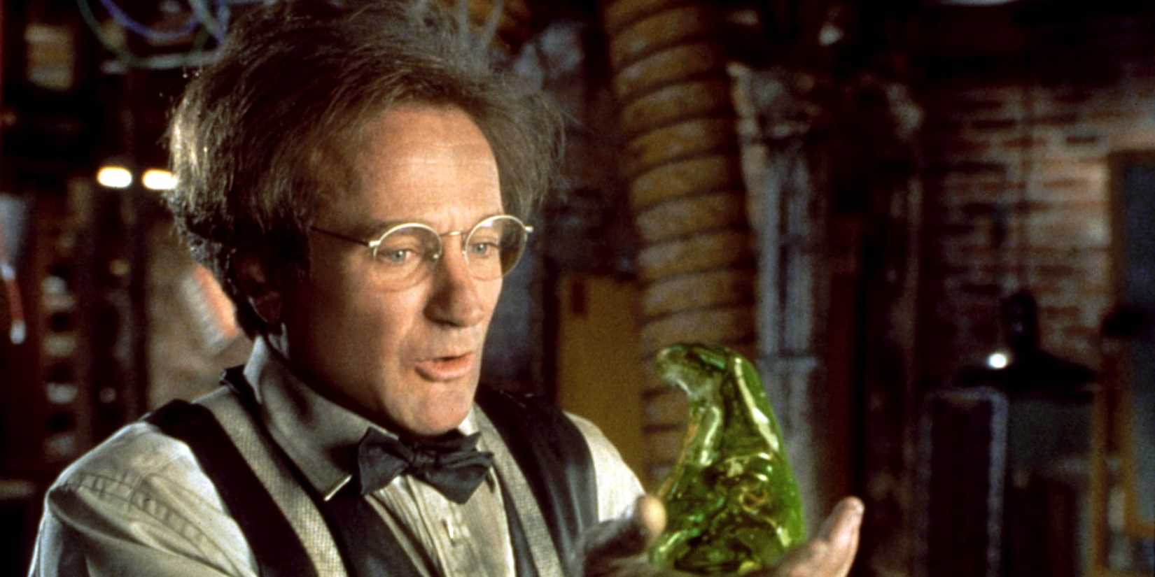 Robin Williams as Professor Philip Brainard holding and looking at the green blob Flubber in Flubber