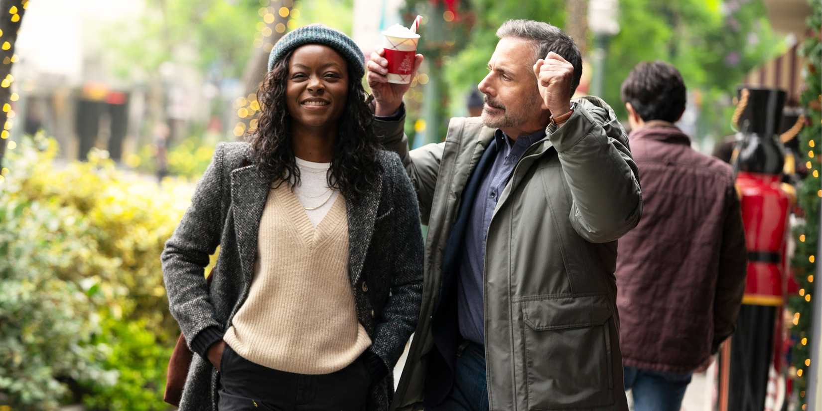 Greg is turned towards Dylan, dancing, as they walk down a sidewalk.