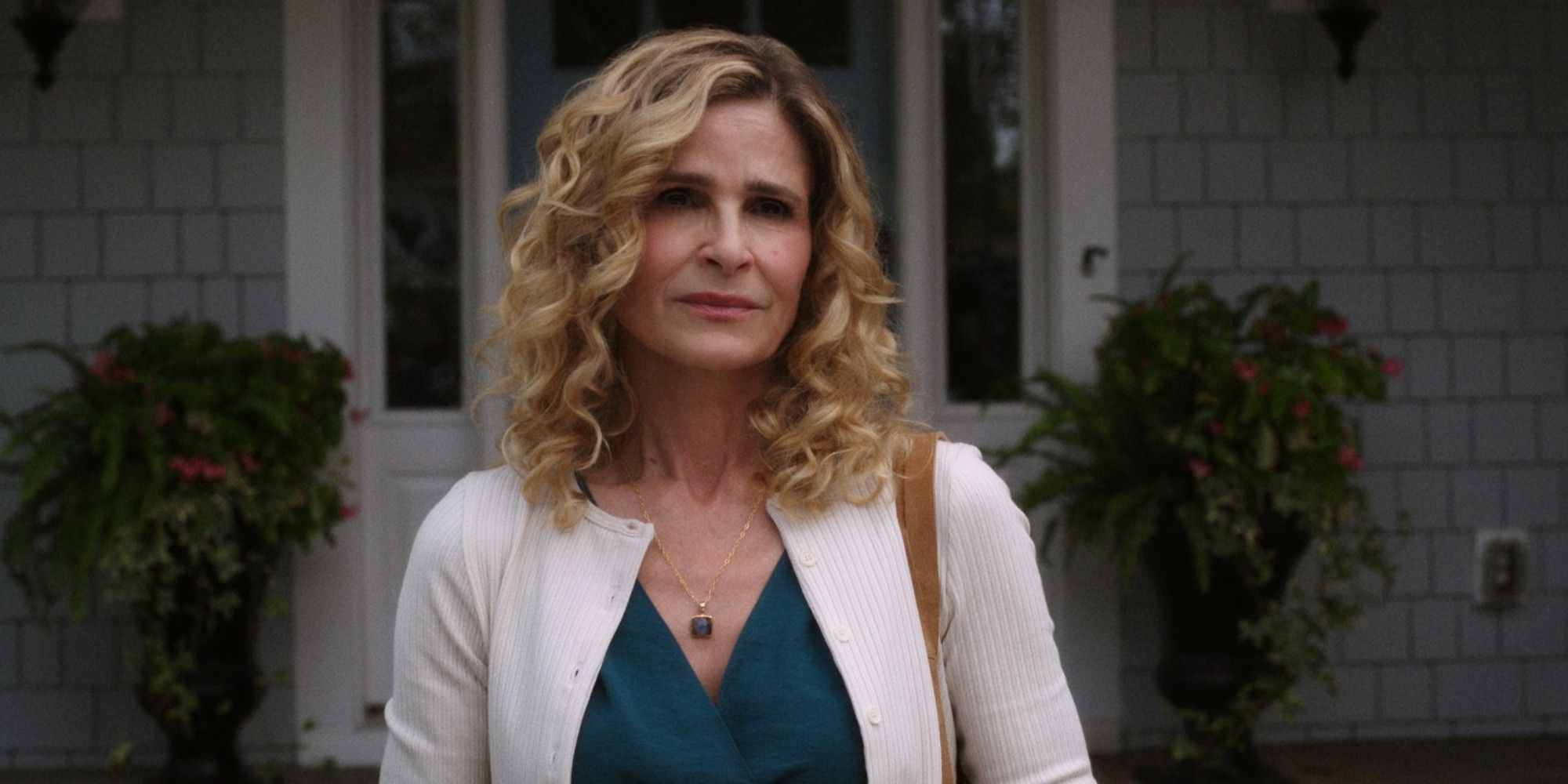 Kyra Sedgwick stands outside watching someone from the front lawn, in The Summer I Turned Pretty