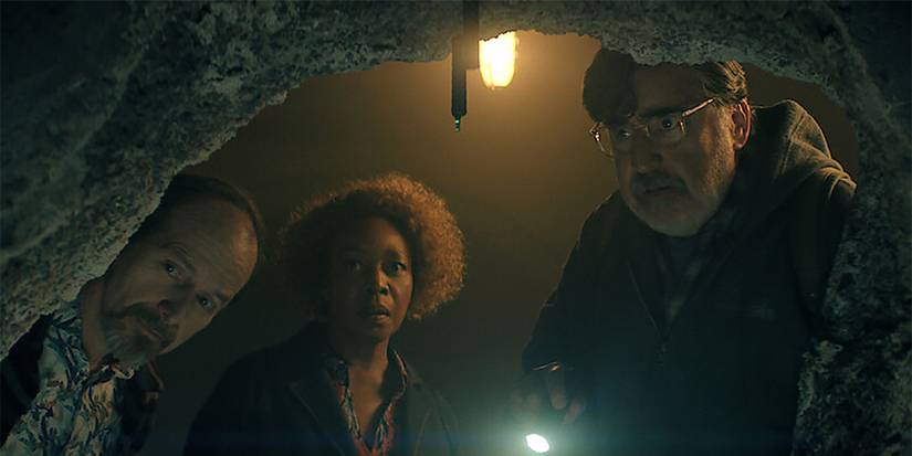 Two older men and an older woman inspecting a cave in The Boroughs.