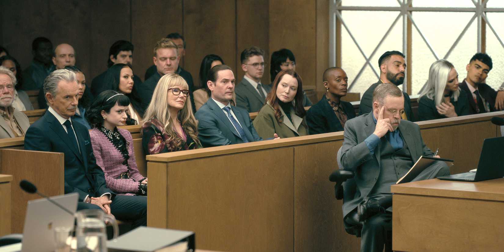 Mark Hamill sits as the attorney for the Usher family who all sit behind him in court