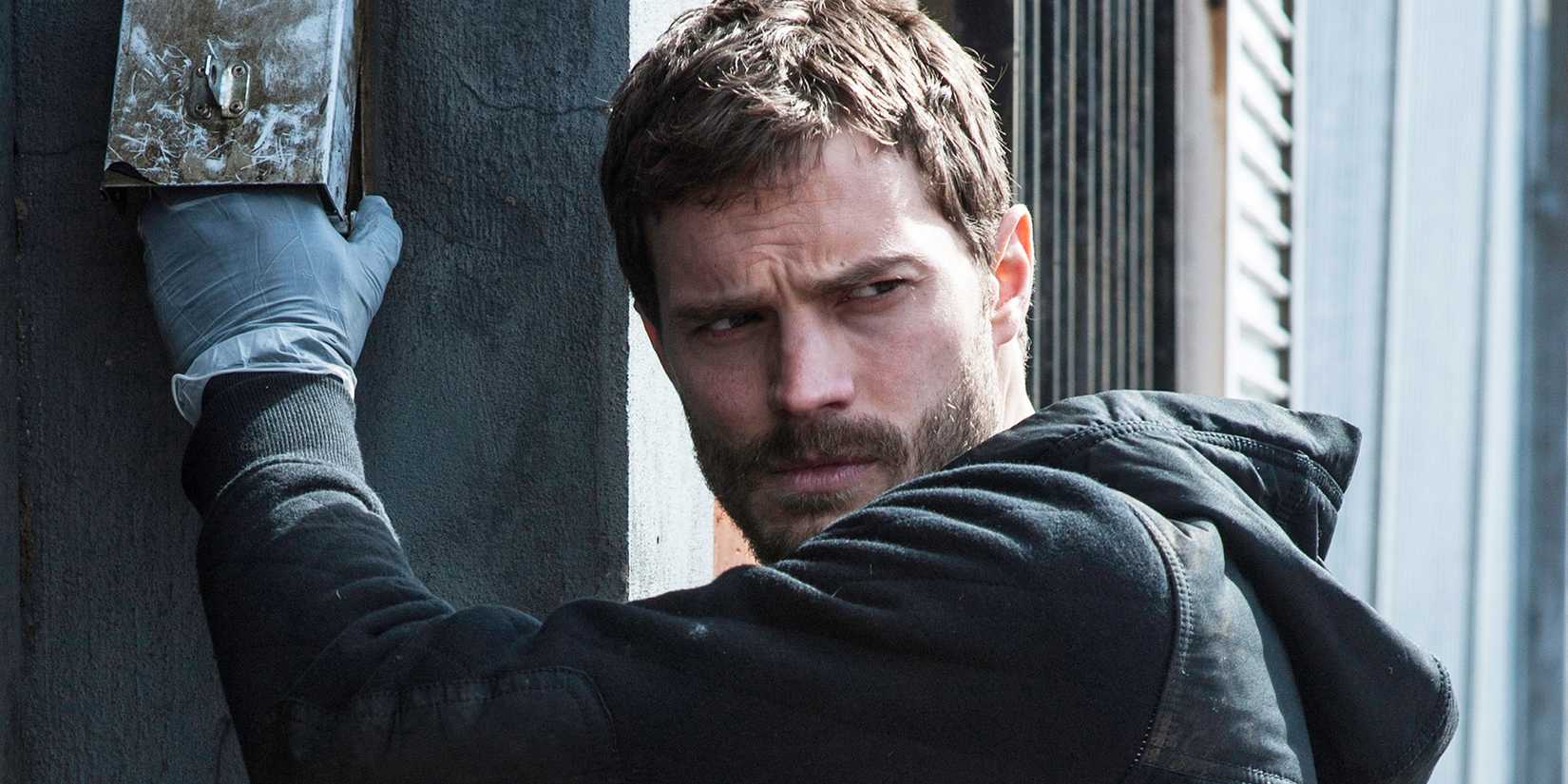 Jamie Dornan looking seriously over his shoulder in The Fall