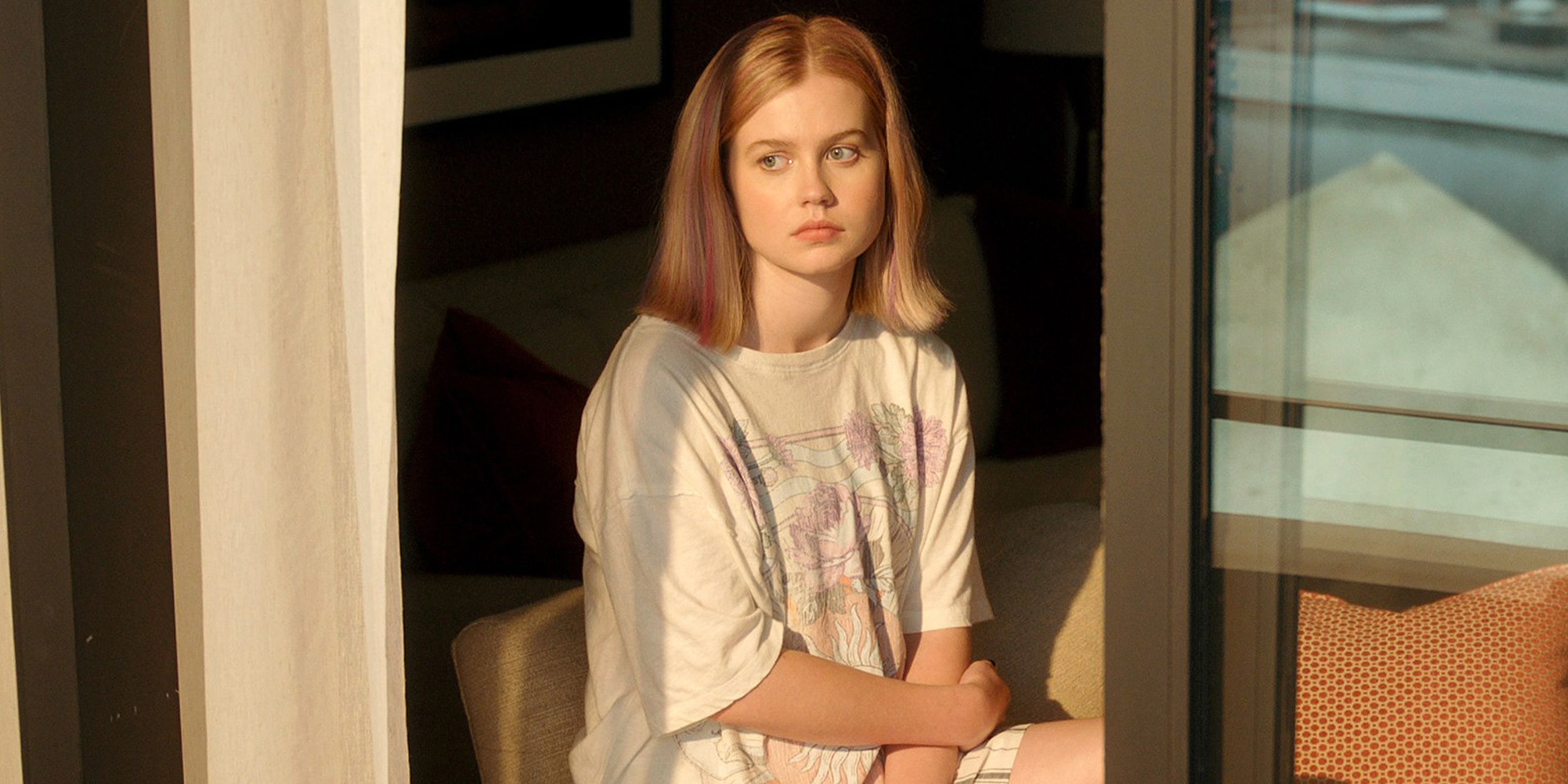 Angourie Rice sits in a white tee shirt and looks out a window in 'The Last Thing He Told Me'