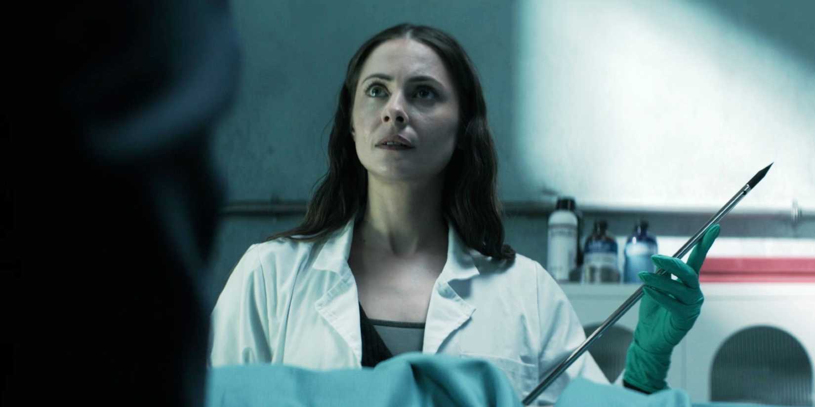 Willa Holland holding a pick while staring at someone in The Mortuary Assistant