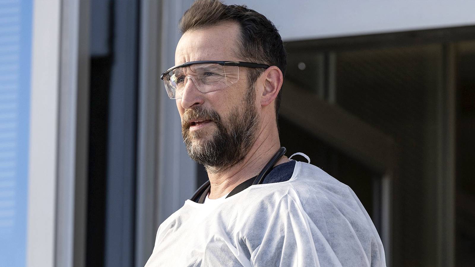 Noah Wyle steps outside in his medical gear on The Pitt