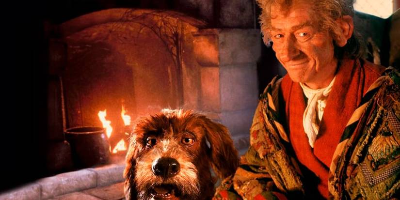 John Hurt as The Storyteller next to his dog voiced by Brian Henson by a fireplace in Jim Henson's The Storyteller