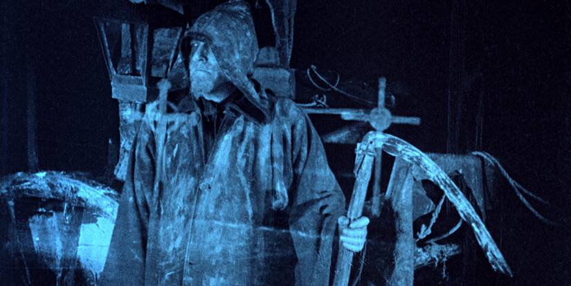 A man in a hood holding a scythe in 'The Phantom Carriage' (1921)