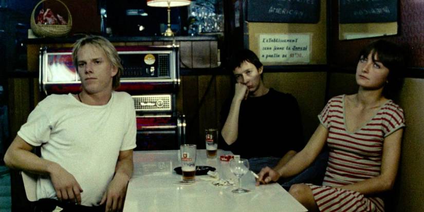 Three people sitting at a table in 'Toute une nuit'