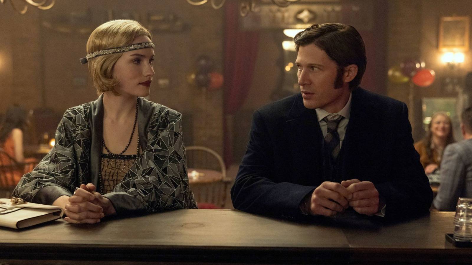 The Usher siblings dressed up and looking at each other at a bar