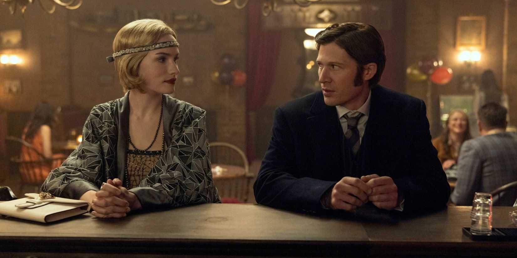 The Usher siblings dressed up and looking at each other at a bar