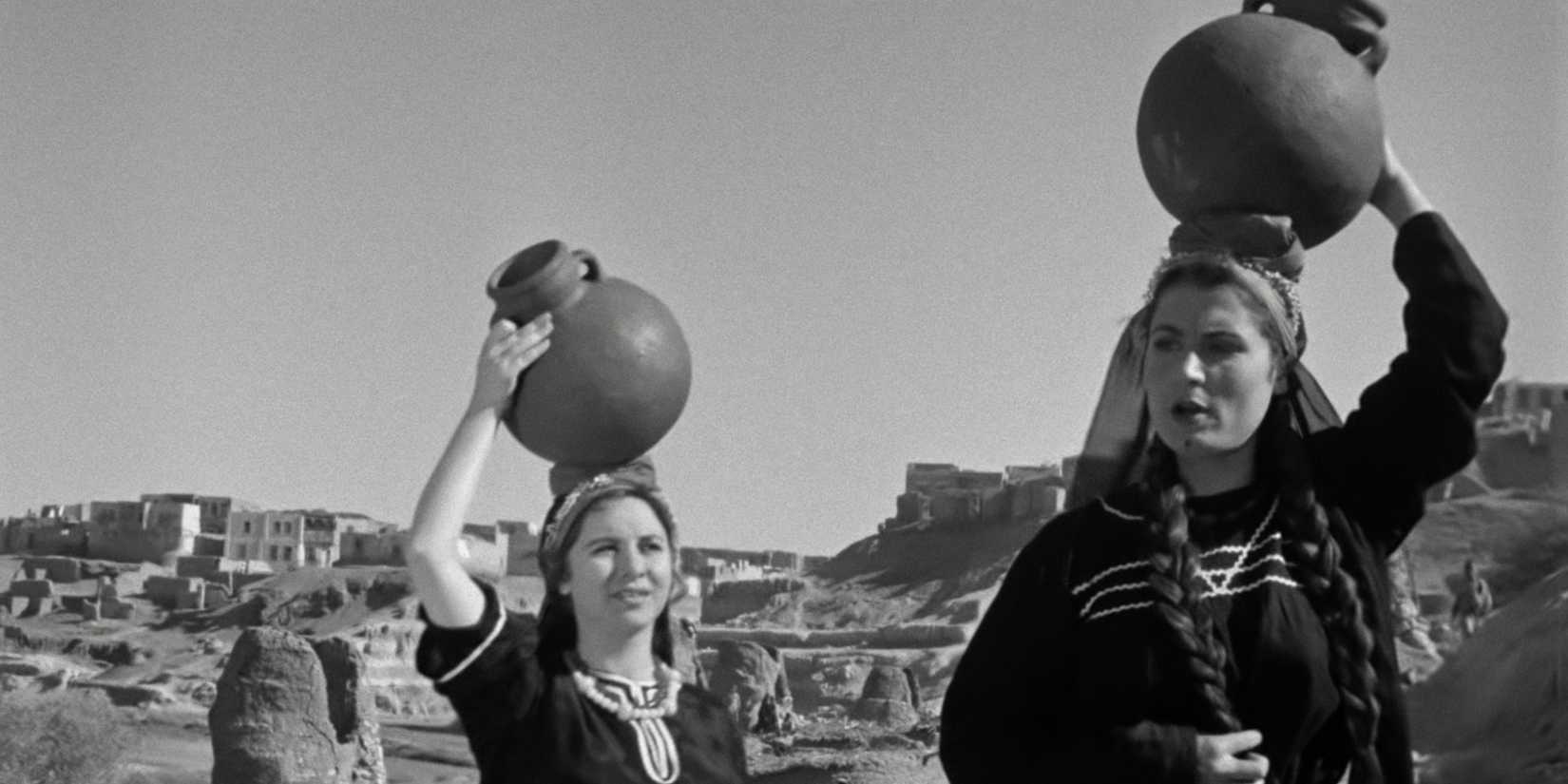 Women carrying water above their heads in 'The Nightingale's Prayer'