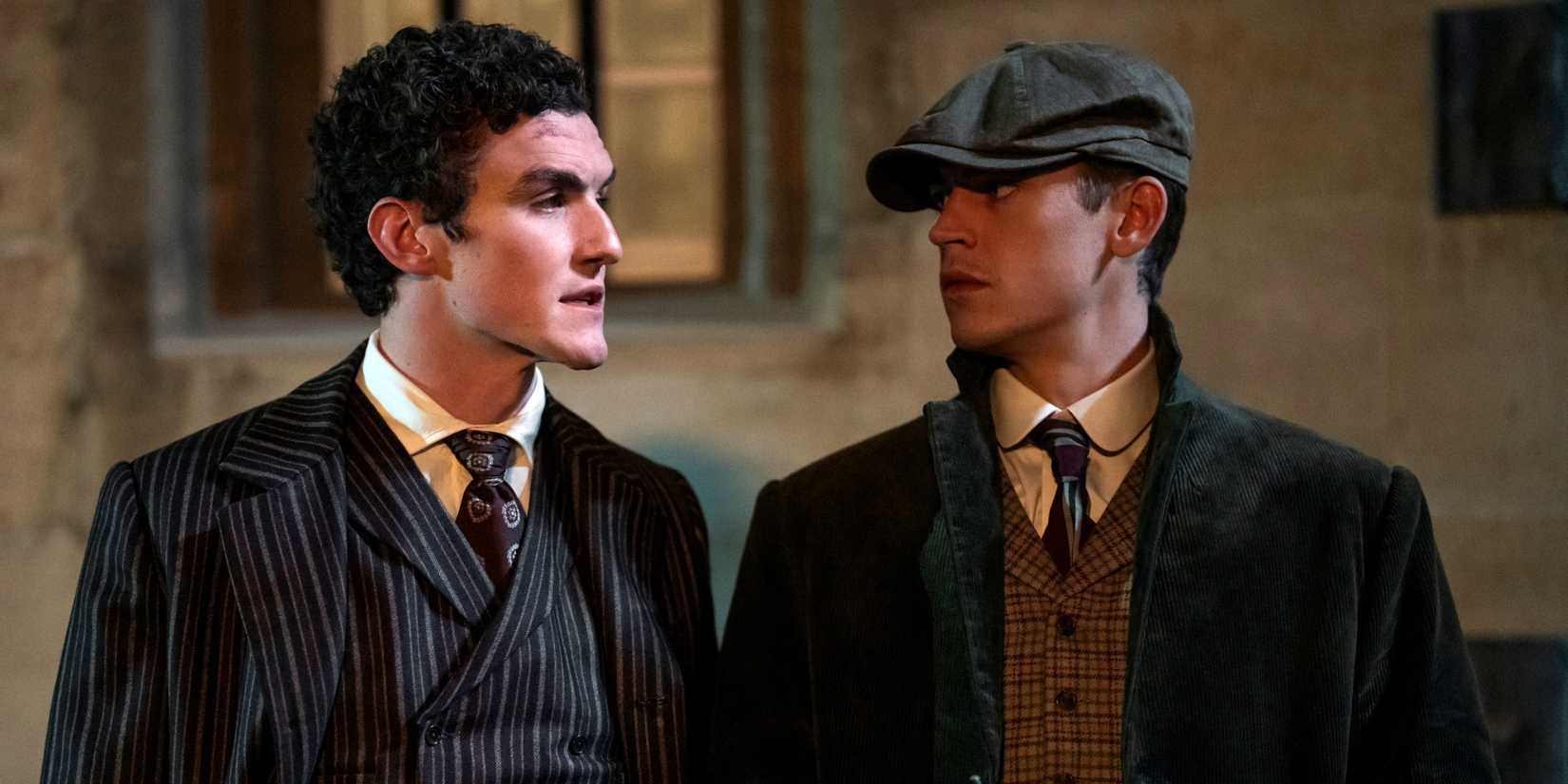 Hero Fiennes Tiffin as Sherlock and Dónal Finn as Moriarty standing next to each other in Young Sherlock