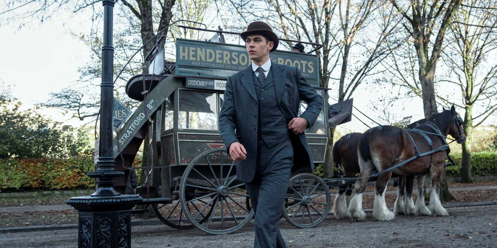 Hero Fiennes Tiffin as Sherlock Holmes walking outside in a three-piece suit in Young Sherlock