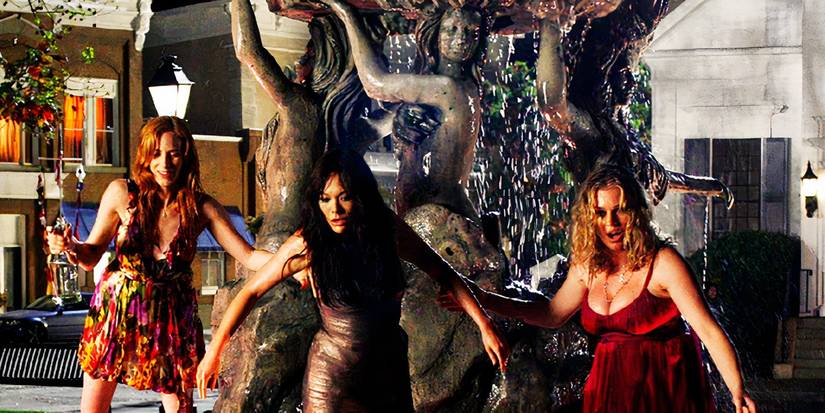 The main characters of the 2009 series Eastwick in a fountain holding onto each other as they step out.