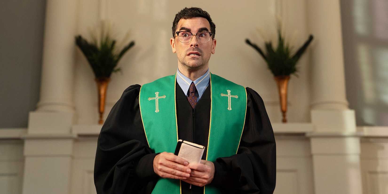 Nicky holds a bible and looks off the side surprised. 